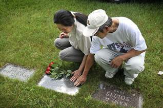 Bich Thuan Nguyen and Anh Van Duong visit their son Anthony's grave.
