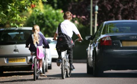 two children cycle to school (posed by models)